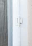 Zawiasy samodomykające w moskitierze drzwiowej w kolorze białym