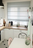 Roleta rzymska o gładkiej transparentnej tkaninie w kolorze szarym (DZT55) na oknie w kuchni o stylu skandynawskim.