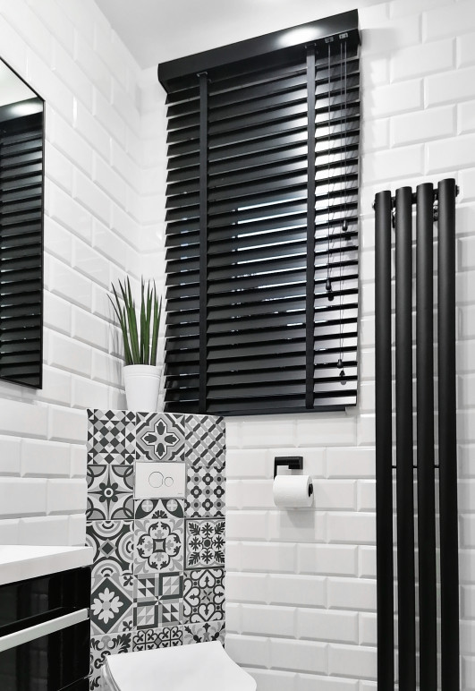 Żaluzja drewniana w kolorze czarnym o lamelkach 50mm drabinka taśmowa montaż nad wnęką w łazience.