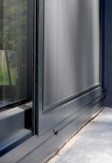 Aluminiowe drzwi moskitierowe przesuwne jednoskrzydłowe w kolorze antracyt na drzwiach tarasowych