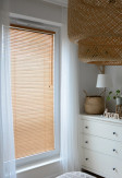 Żaluzje bambusowe 25mm w kolorze graham z widoczną i naturalną strukturą drewna na oknie w salonie.